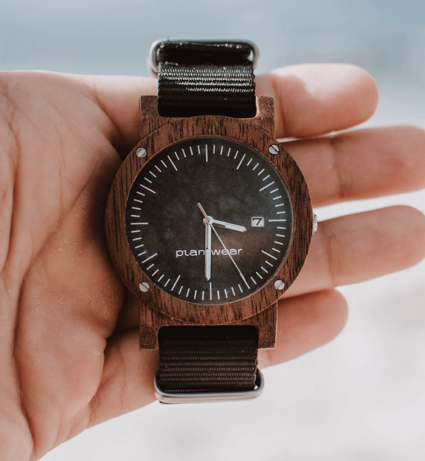 wooden watch with brown crown and black strap