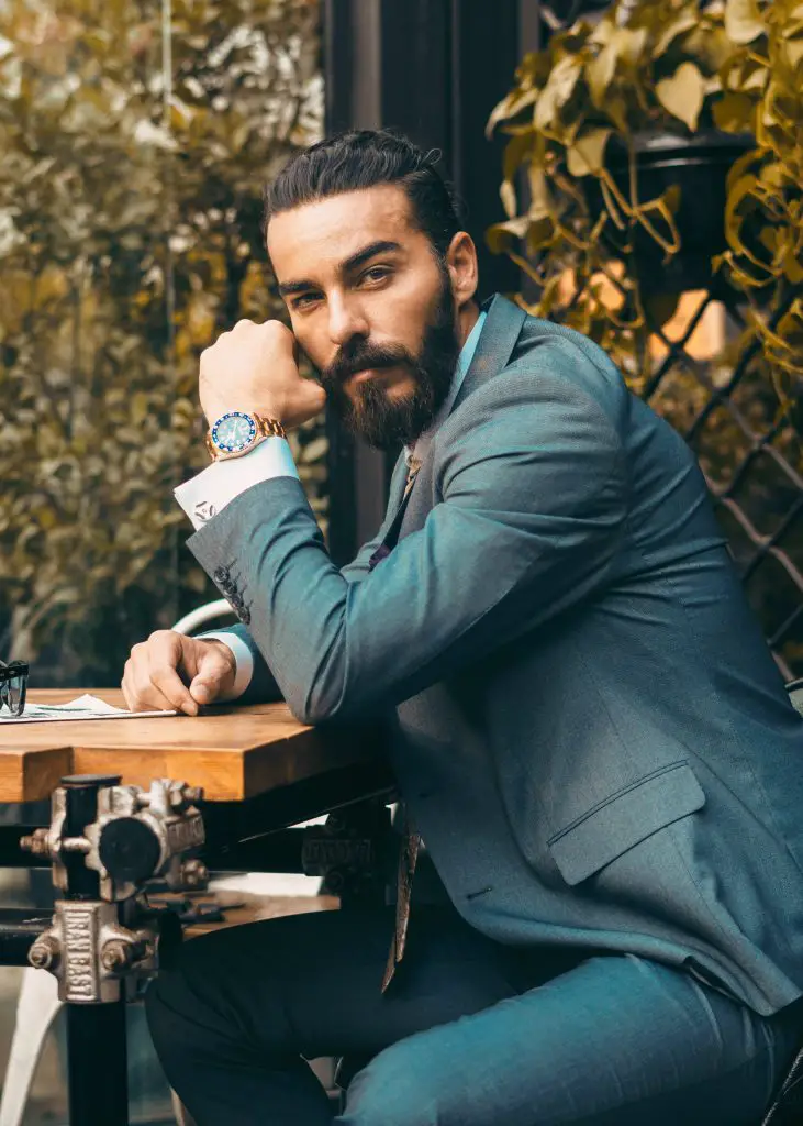 confident and stylish man sitting at a table