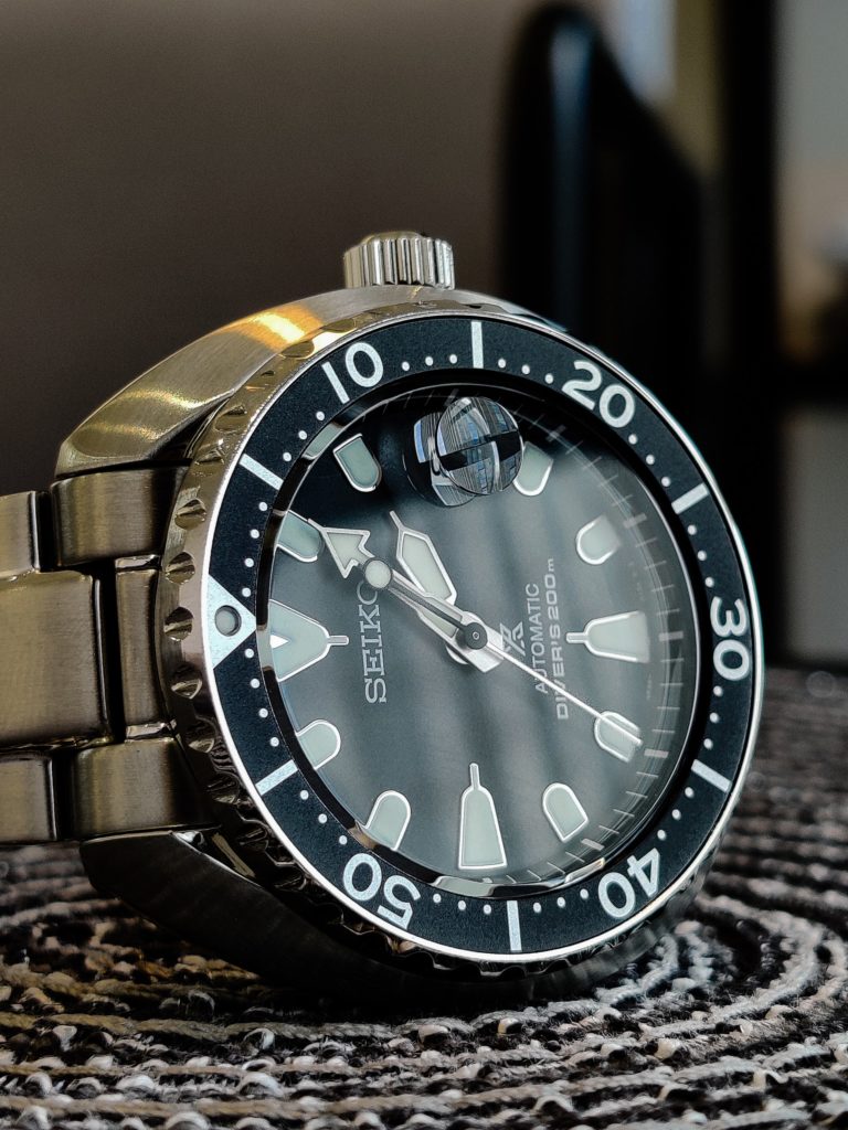 Metallic diver's watch with rotating bezel and domed crystal