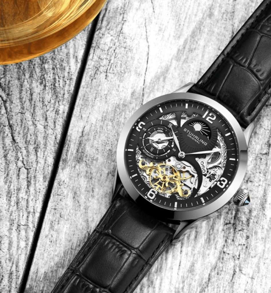 Stuhrling skeleton watch on a grey wooden table