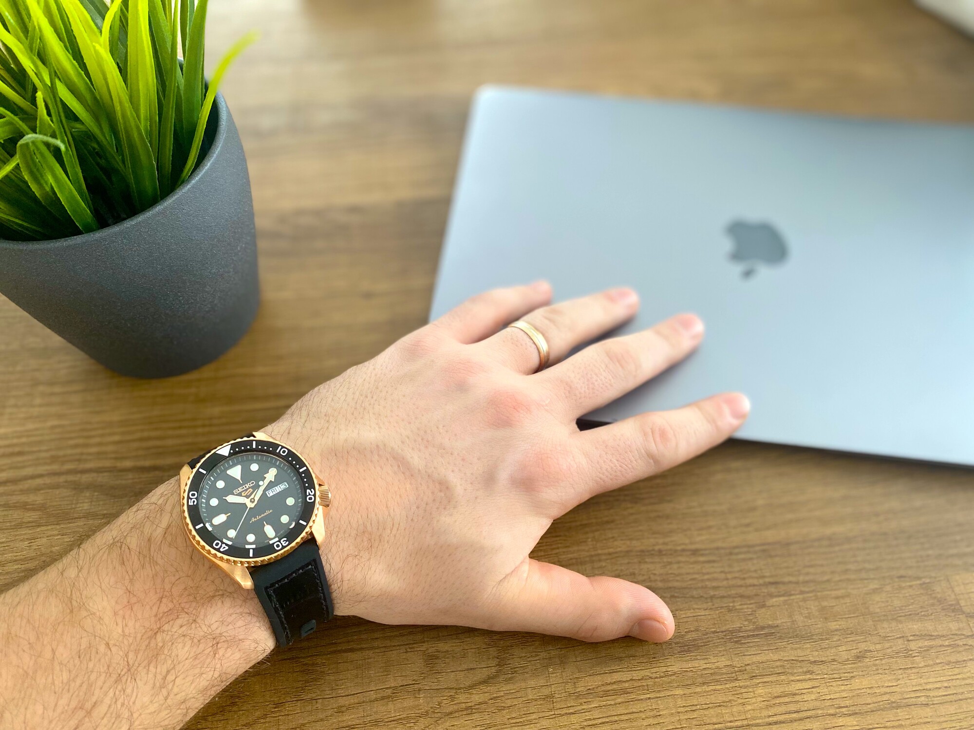 A dark-toned watch next to Macbook Air