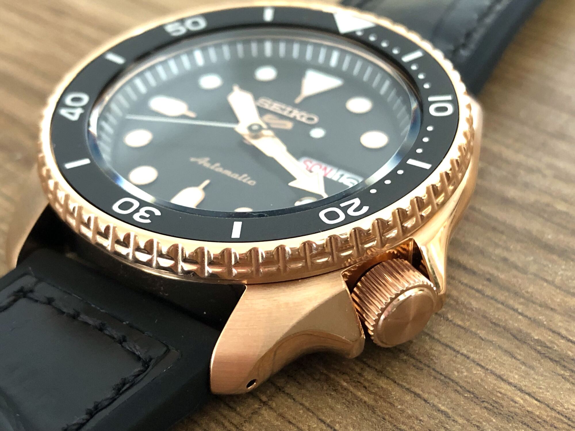 Rose-gold tone case with black dial and crown protectors