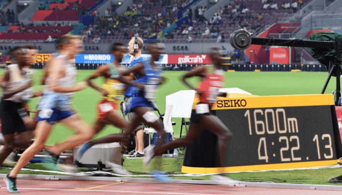 runners competing with Seiko time being at the background