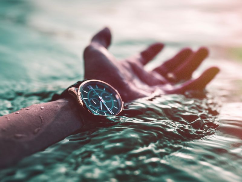 A watch inside wrist in the water