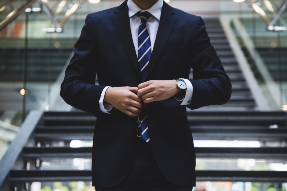 A gentleman wearing a watch with black tie